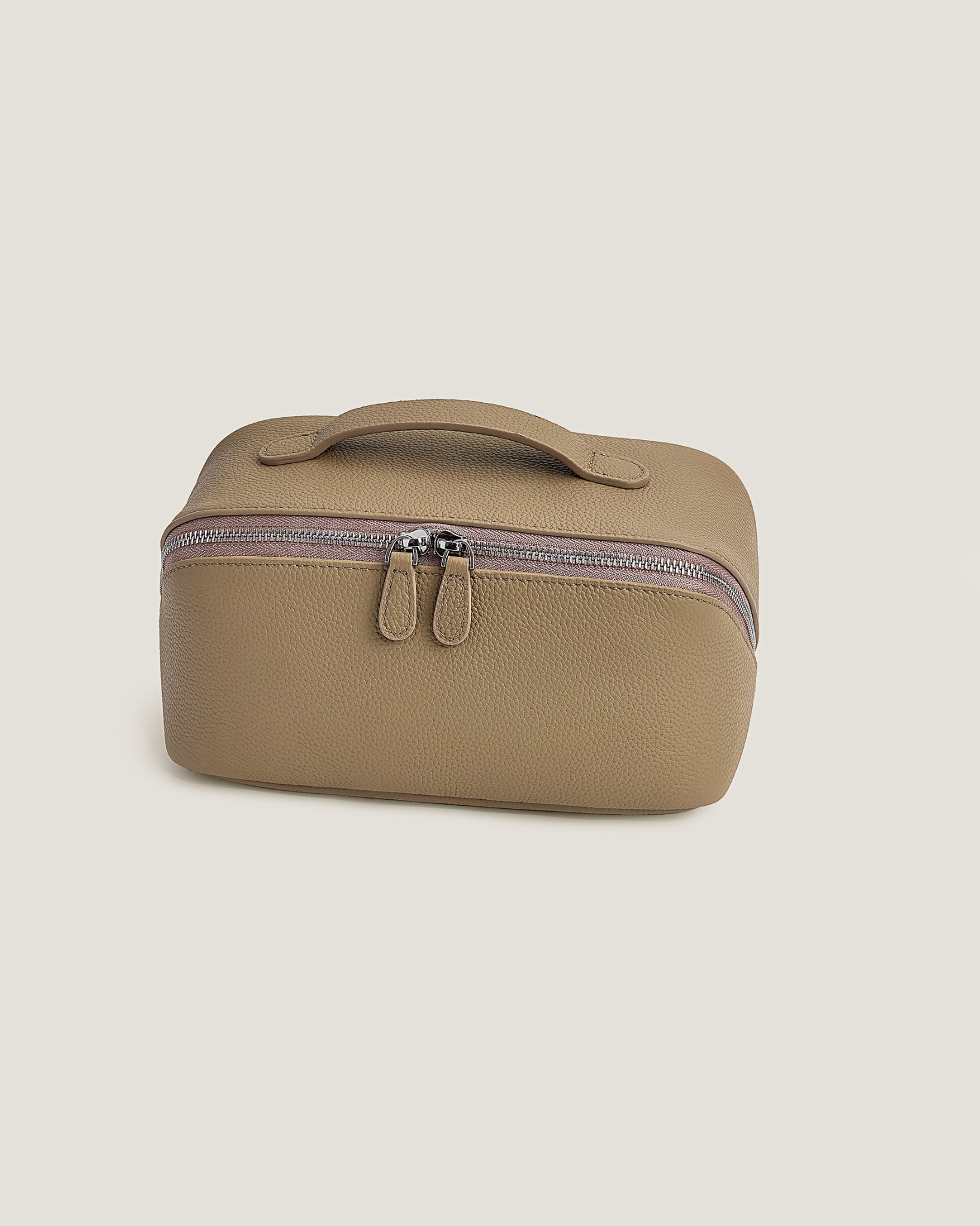 Beige makeup bag with a zipper on a beige background