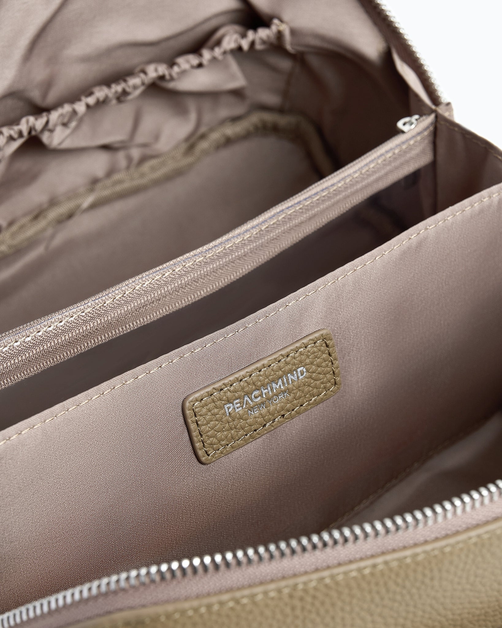 Beige makeup bag with a zipper on a beige background