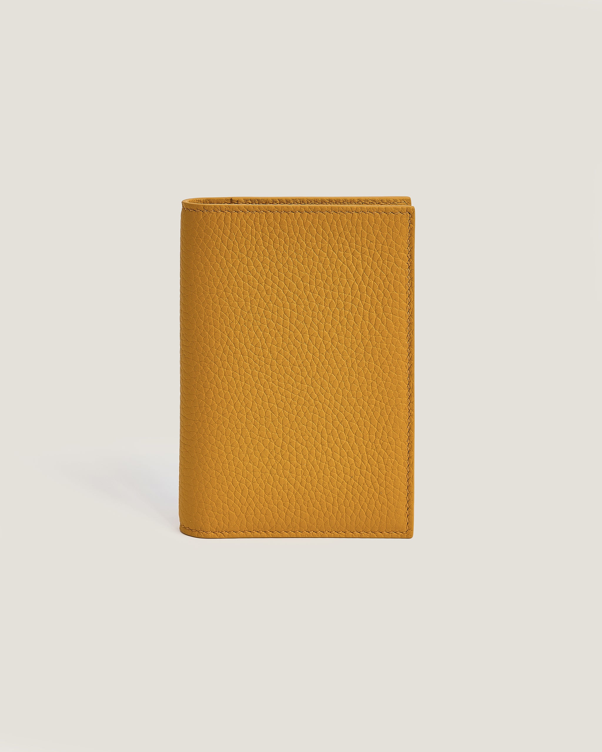 Yellow leather wallet on a light beige background